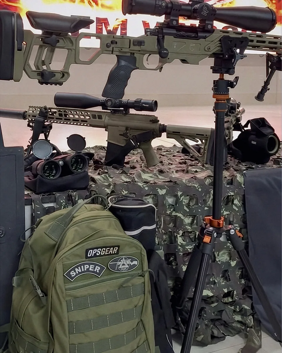 Mochila tática verde OPSGEAR com patches ao lado de equipamento de precisão